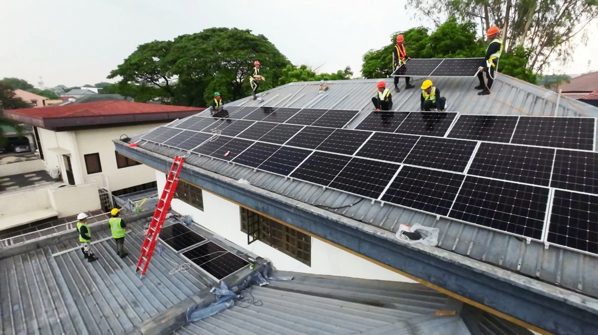 Solar technician installing panels on rooftop
